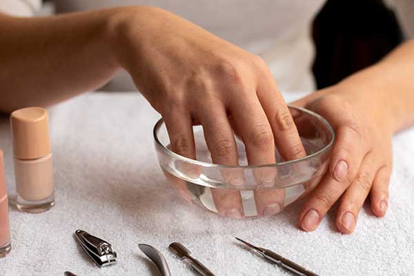 Main qui retire les capsules press-on sans abîmer ses ongles