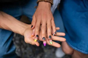 Main homme et femme qui portent des capsules pour faux ongle