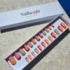 Faux ongles press-on colorés avec motifs ondulés multicolores rose, orange, vert, bleu et jaune sur base nude en forme carrée