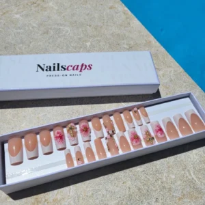 Sakura Élégance, faux ongles press-on nude avec French blanche, fleurs roses 3D, détails dorés et strass élégants