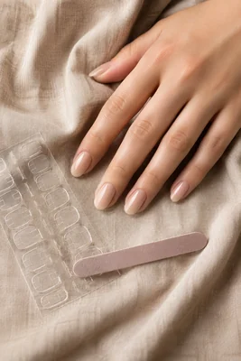 Press-on nails nude posés avec des pads adhésifs pour une tenue confortable